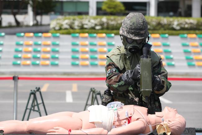 한미연합 의무지원 야외기동훈련에서 국군춘천병원 장병이 가상의 환자를 제독한 뒤 화학작용제 탐지장비로 추가 제독 여부를 확인하고 있다.