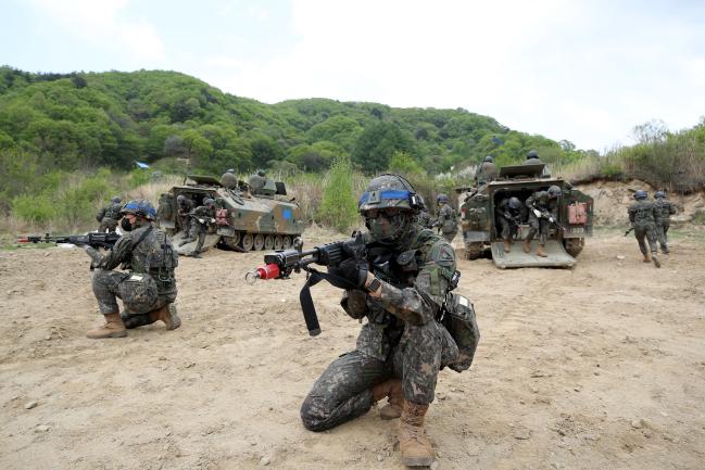 신임 장교들이 K200 장갑차에서 하차해 전투 준비를 하고 있다.