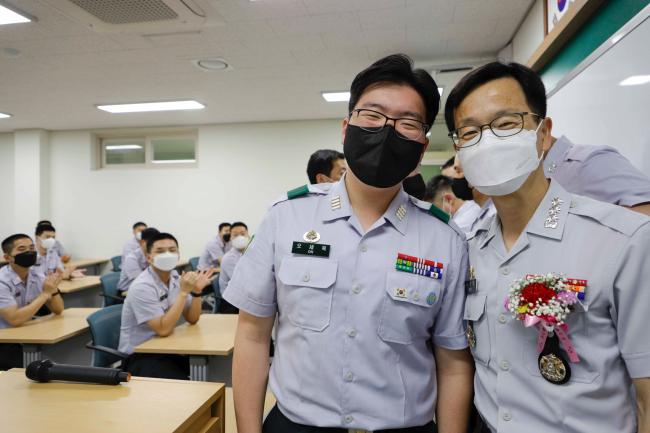 육군3사관학교 전자공학과 오세욱(왼쪽) 생도가 두석주 공학처장에게 카네이션을 달아준 뒤 기념사진을 찍고 있다.  부대 제공