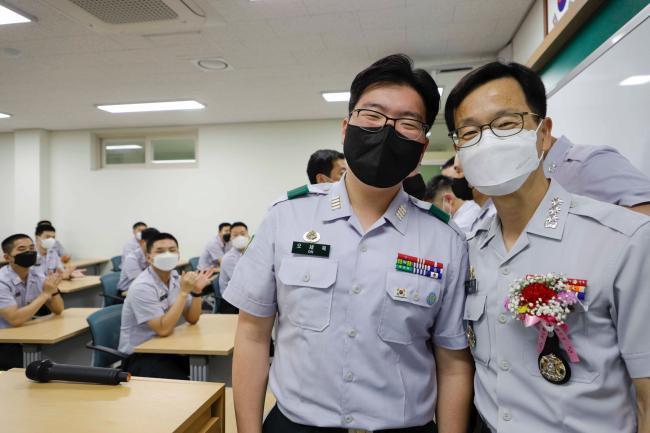 육군3사관학교 전자공학과 오세욱(왼쪽) 생도가 두석주 공학처장에게 카네이션을 달아준 뒤 기념사진을 찍고 있다.  부대 제공