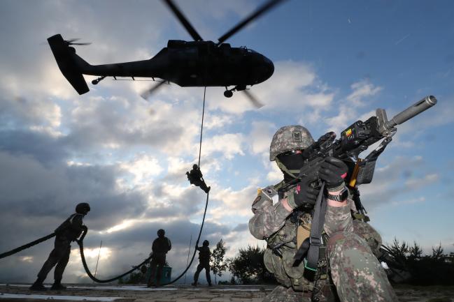  26일 강원도 인제에서 펼쳐진 육군3군단 지상협동훈련에서 군단 특공연대 장병들이 UH-60 블랙호크 헬기에서 급속 헬기 로프 하강을 하고 있다.