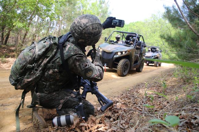 육군21보병사단 전투촬영팀원이 전술다기능단말기를 활용해 시각정보를 획득하고 있다.  부대 제공