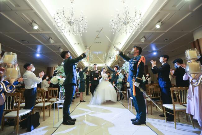 밀리토피아 웨딩홀은 인생에 가장 빛나는 순간인 결혼식을 더욱 찬란하게 만들어 주기 위해 품격 있는 서비스를 제공하고 있다. 사진은 현역 장교 신랑과 신부가 많은 사람들의 축복 속에 버진로드를 걸어나오는 모습. 