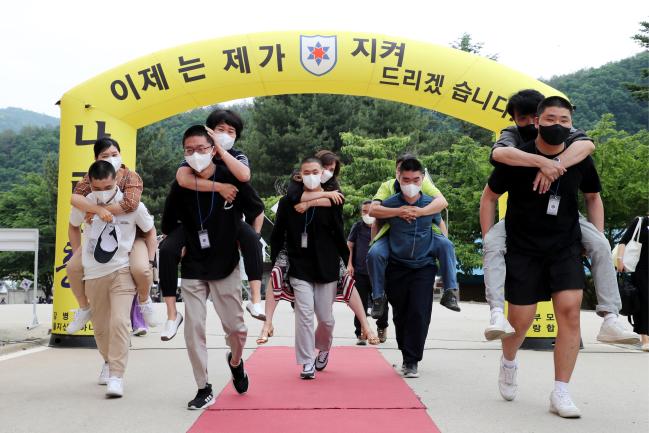 30일 육군12보병사단이 2년 3개월여 만에 재개한 가족 동반 입영식에서 입영 장정들이 부모님을 업고 레드카펫을 걸으며 감사의 마음을 전하고 있다.
