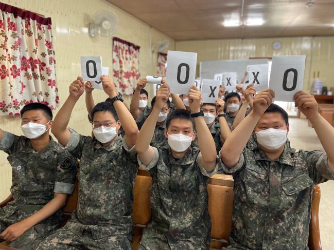 육군35보병사단이 지난 3일 개최한 ‘해안경계작전 집중지원의 날’ 행사에서 ‘도전! 충경 골든벨’에 참가한 장병들이 OX 퀴즈를 풀고 있다.  부대 제공 