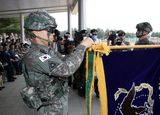 박정환 육군참모총장이 계룡여단 부대기에 ‘아미타이거 시범여단전투단’ 부대 수치를 달아주고 있다.