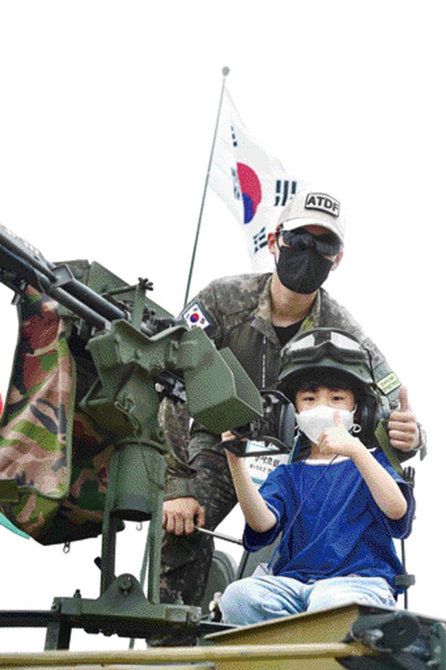 드론봇 페스티벌 중 전시된 전투 장비에 탑승한 어린이와 안내 장병.