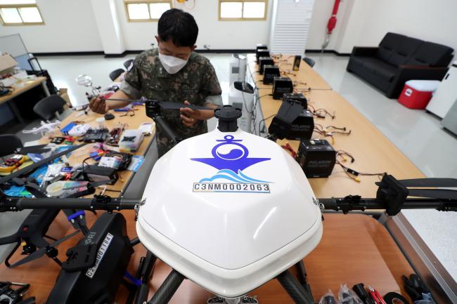원활한 실습 교육을 위해 드론과 부품을 정비하는 해양무인체계 교육센터 교관들.