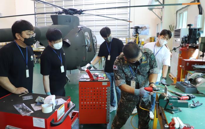 육군항공학교 정비사가 항공기 정비교육에 참가한 논산공고 학생들에게 정비 시범을 보이고 있다.  부대 제공