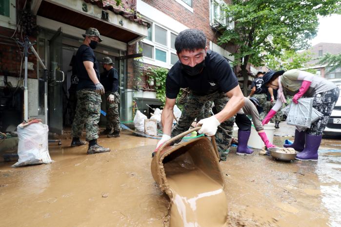 흙탕물 걷어내고
육군특수전사령부 독수리여단 장병들이 10일 서울 관악구 청룡동에서 주택 내부로 들어온 흙탕물을 퍼 길 밖으로 빼내고 있다. 