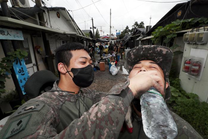 물 한 모금 마시고 다시 시작
서울 송파구 장지동 화훼마을에서 대민지원에 나선 장병들이 서로에게 물을 먹여 주고 있다. 