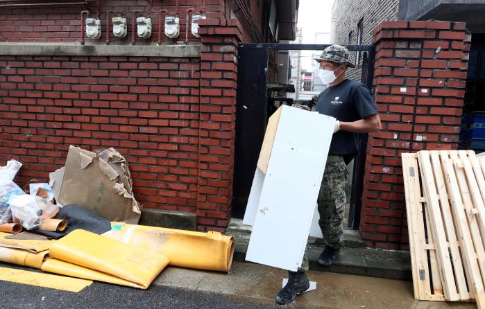 끝없이 나오는 수해 폐기물  11일 특전사 귀성부대 독사대대 장병들이 관악구 신사동 주택가에서 물에 젖은 가구를 번쩍 들어 옮기고 있다.