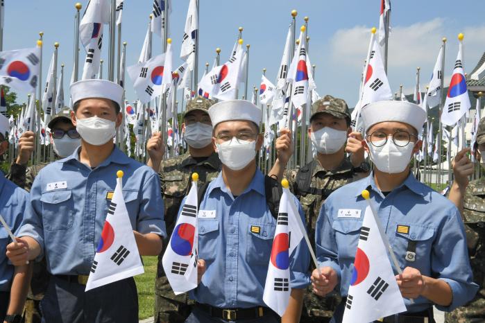 지난 12일 충남 천안시 독립기념관을 방문한 해군인천해역방어사령부 장병들이 ‘한국광복군 서명문 태극기’ 앞에서 태극기를 손에 들고 기념 촬영을 하고 있다.  사진 제공=양성기 상사