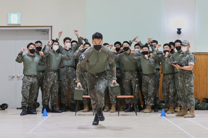 육군8군단 예하 풍호대대 장병들이 ‘일행다득’ 집중정신전력교육 프로그램 중 하나인 ‘최강팀 선발전’을 하고 있다. 탄통을 나르는 참가자 뒤로 열띤 응원전을 펼치는 장병들의 모습이 보인다.