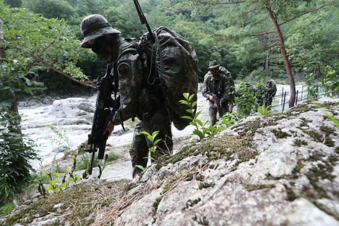 장병들이 설악산 대청봉을 향해 기동하고 있다. 그 옆으로 시원한 계곡 물이 흐르고 있다.