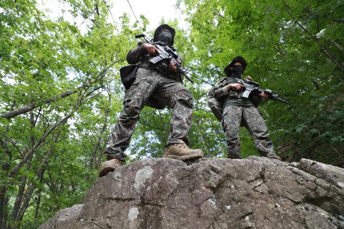 탐방로 행군 중 바위를 넘고 있는 특공연대 장병들.