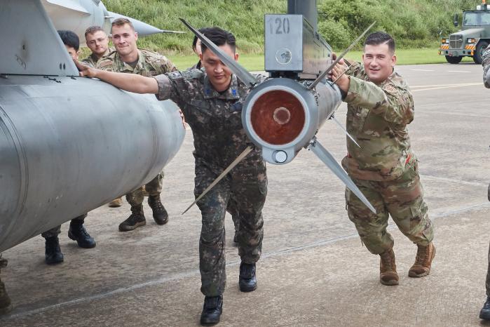 합심해 KF-16 전투기를 이동시키고 있는 한미 공군 정비사들.