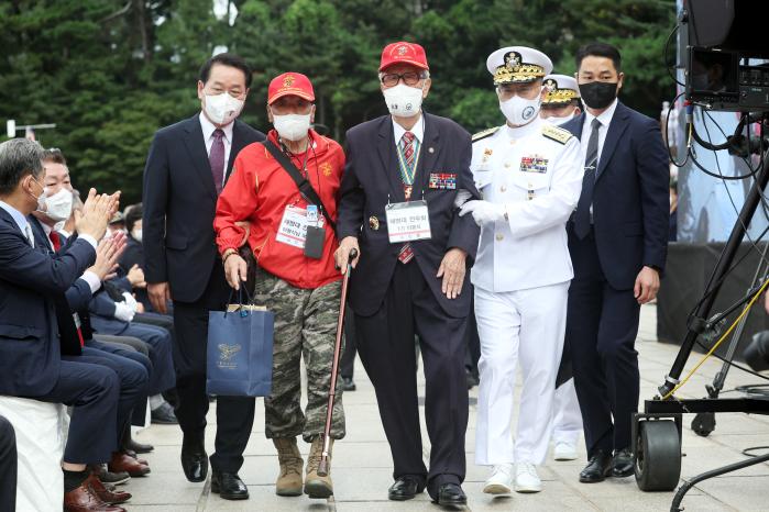 이종호(오른쪽) 해군참모총장이 인천상륙작전 참전용사 이봉식 옹을 부축하며 행사장에 입장하고 있다.