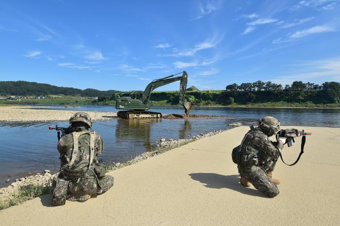 26일 다그마노스 미군 훈련장에서 열린 육군1보병사단 공병대대와 한미연합사단 11공병대대의 연합 공병 전술훈련 중 우리 측 굴착기가 강바닥을 파내 수심을 확보하는 동안 1사단 장병들이 주위를 경계하고 있다.