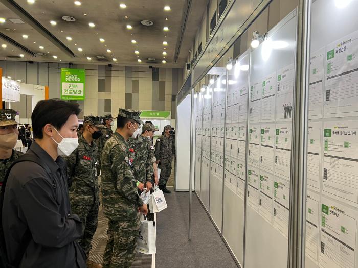 박람회 참석 장병들이 행사장에 게시된 기업 채용 공고를 살펴보고 있다. 