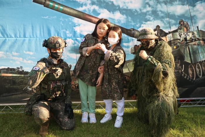 육군56보병사단 도봉대대가 제74주년 국군의 날을 기념해 서울 도봉구청 잔디광장에 마련한 장비 전시 체험장에서 어린이들이 대대 장병들과 기념사진을 찍고 있다. 사진 제공=서승철 대위