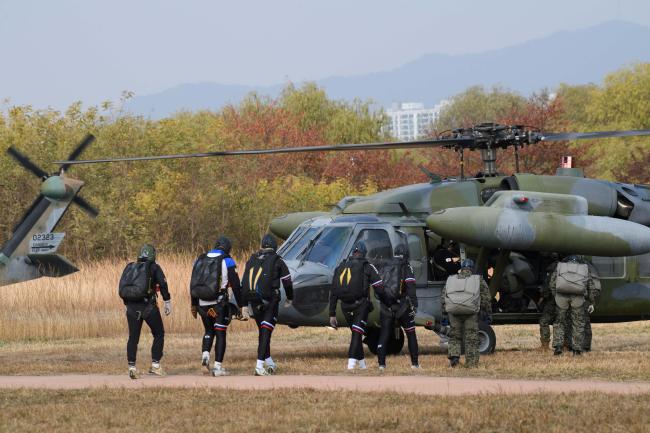 참가자들이 UH-60 블랙호크 헬기를 타기 위해 이동하는 모습.