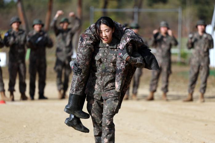 정보중대 박대웅 중사가 전장순환운동 훈련 중 더미를 어깨에 걸쳐 메고 달리는 모습.