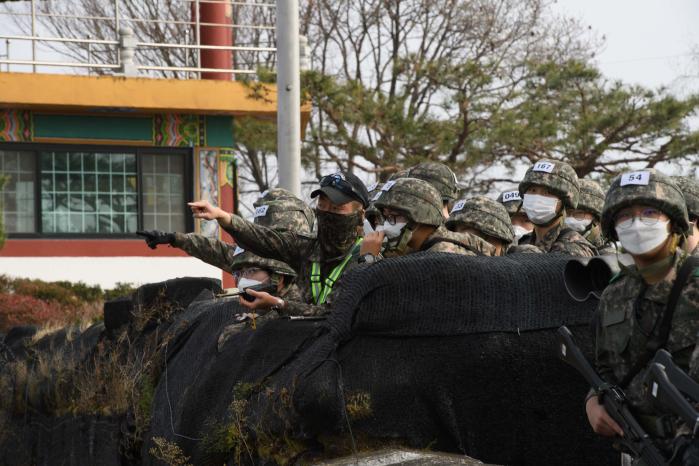 전술행군 중 교관이 비무장지대(DMZ)를 배경으로 부대 역사를 교육하고 있다.