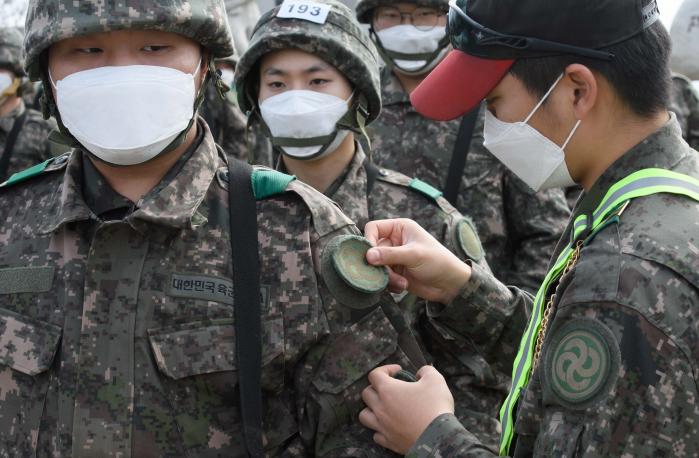 조교가 행군을 마친 훈련병에게 사단 마크를 부착해주는 모습.