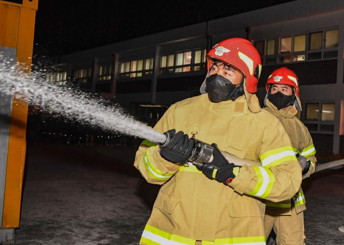 지난 24일 해군군수사령부 병기탄약창 장병들이 병영생활관에서 발생한 모의 화재 진화에 나서고 있다.  사진 제공=신연주 중사