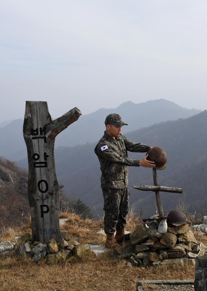 현장취재에 동행한 육군7보병사단 정훈병 이비오 상병이 9일 오전 강원 화천군의 방패막이라 할 수 있는 백암OP 정상에서 세워져 있는 비목을 바라고 있다. 정전협정을 앞두고 치열하게 벌어진 금성전투의 핵심 전투지로 국민가곡 비목의 직접적인 배경인 백암OP는 과거 병력이 상주하던 GP였으나 지금은 감시카메라로만 운영되고 있다.