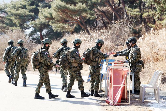 훈련에 앞서 부사관들이 땅바닥에 손을 대는 접지 과정으로 몸에 남은 전류를 제거하고 있다.