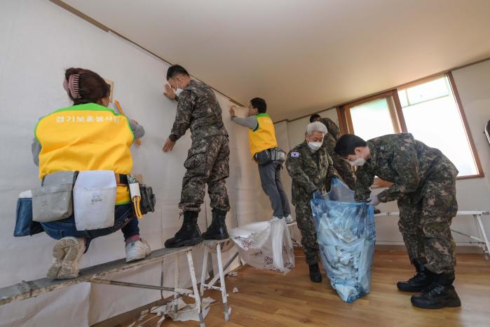 해군2함대 2해상전투단 장병들과 경기 보훈봉사단 봉사자들이 평택시 포승읍 원정7리 마을회관에서 도배 봉사활동을 하고 있다. 부대 제공