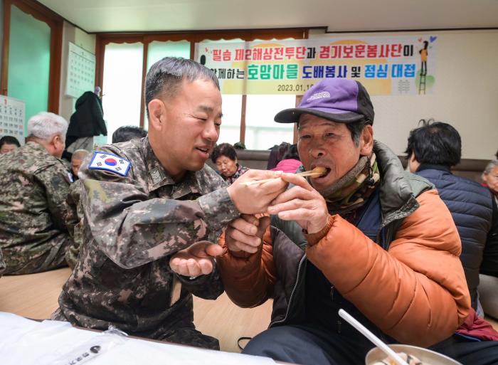 해군2함대 2해상전투단 장병들과 경기 보훈봉사단 봉사자들이 평택시 포승읍 원정7리 마을회관에서 떡국을 만들어 어르신들에게 대접하고 있다. 부대 제공