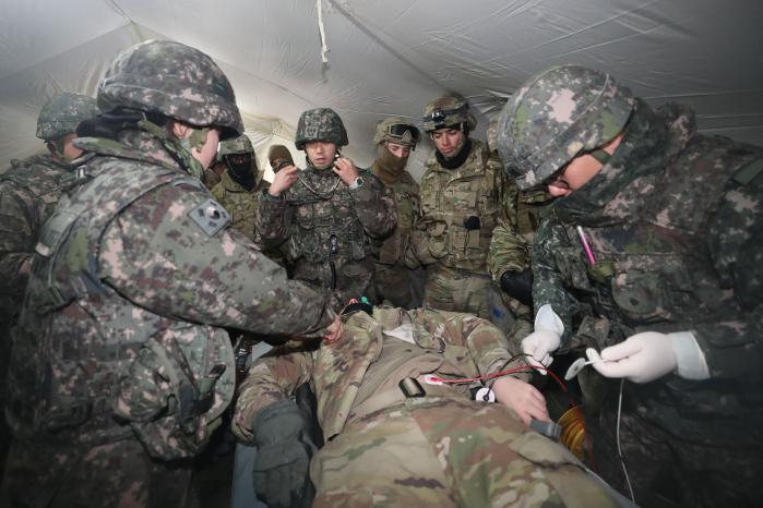 육군수도기계화보병사단 의무대와 미2사단·한미연합사단 스트라이커여단 의무중대 장병들이 26일 캠프 험프리스에서 열린 야전치료소(Role Ⅱ) 설치 연합훈련 중 야전치료소로 옮겨진 환자를 치료하고 있다.