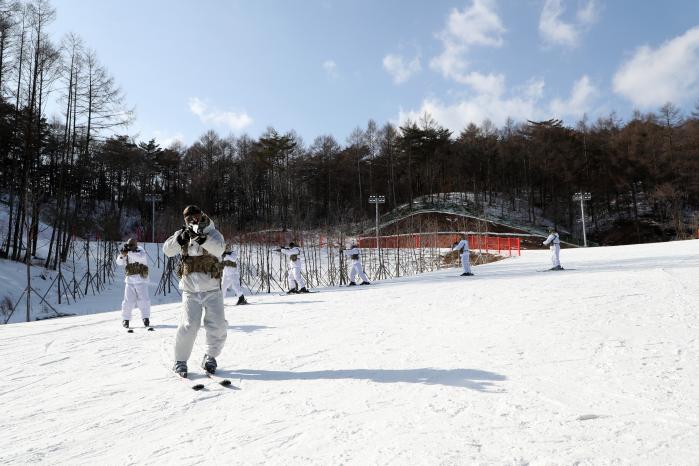 스키 장비를 착용한 특전대원들이 설원을 일렬로 기동하고 있다.