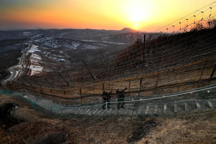 지난 1일 저녁 경기도 연천군 중서부전선 비무장지대 일대에서 육군28보병사단 쌍용여단 GOP 경계 장병들이 노을이 내려앉은 철책로를 따라 걸으며 철책을 점검하고 있다.