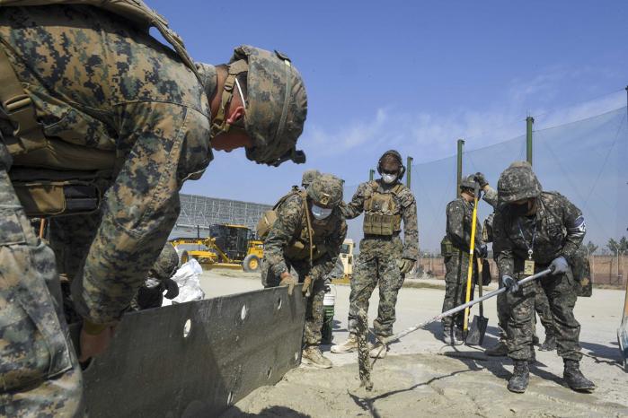 한미 해군·해병대 장병들이 21일 해군항공사령부 활주로 피해복구훈련장에서 초속경 시멘트를 타설해 폭파구를 메우고 있다. 사진 제공=나은정 상사