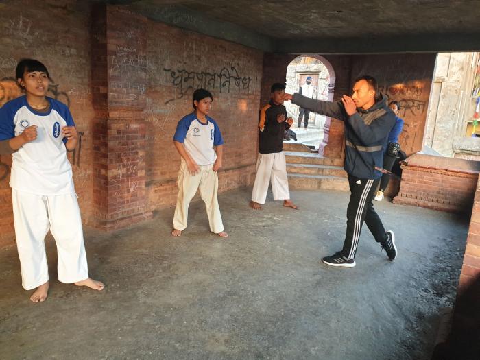 공원 광장 지하 공간에서 합기도를 수련하는 여학생과 무도 사범.