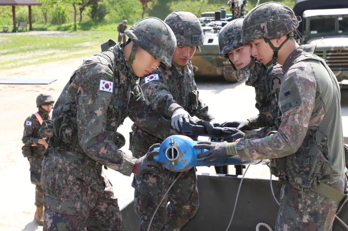 육군7공병여단 공병장비 운용 집체교육에 참가한 장병들이 지뢰지대 개척 선형폭약에 탄두를 결합하고 있다. 사진 제공=조부성 군무주무관