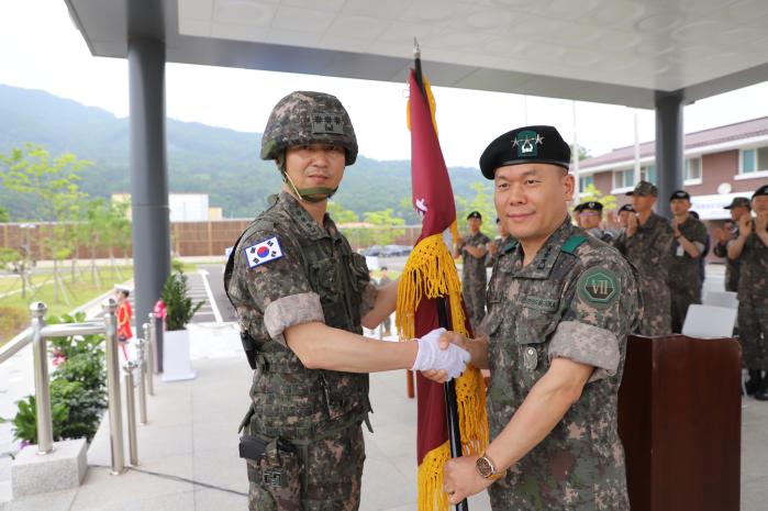 1일 육군7공병여단 예하 도하단 창설식에서 김호복(중장·오른쪽) 7기동군단장이 석진오(대령) 초대 도하단장에게 부대기를 전달하고 있다. 부대 제공