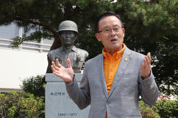 장소길장학회에서 장학금을 받은 수혜자들의 모임인 ‘원길회’ 정주교 회장이 원주고 교내에 있는 장소길 대위의 흉상을 배경으로 그의 희생정신을 설명하고 있다.