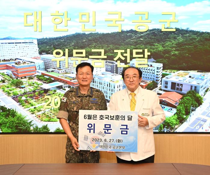 정상화(왼쪽) 공군참모총장이 27일 서울 강동구에 있는 중앙보훈병원을 방문해 유근영 병원장에게 위문금을 전달하고 있다. 공군 제공