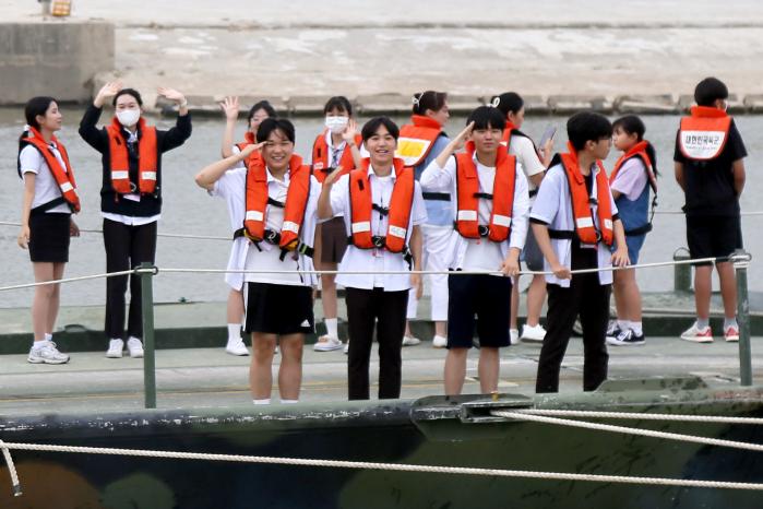 행사에 초청된 지역 학생들이 도하훈련장에서 장병들을 향해 경례하고 있다.