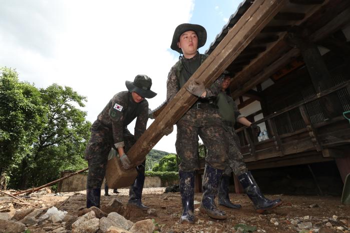 육군50보병사단 기동중대원들이 경북 예천군 민가에서 집중호우 잔해물을 치우고 있다.