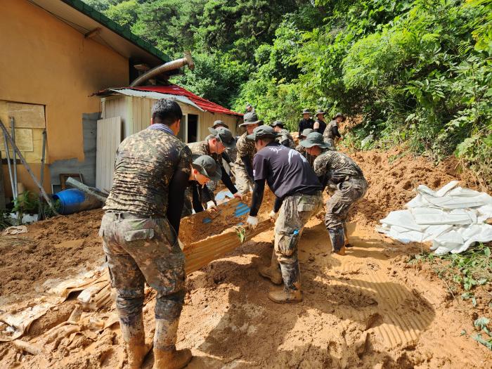 다 함께 육군2신속대응사단 황금독수리여단 장병들이 경북 영주시 단산면에서 주택에 유입된 토사를 퍼내고 있다. 부대 제공