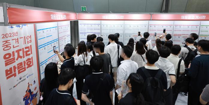 서울 강남구 코엑스에서 열린 2023 중견기업 일자리 박람회를 찾은 청년 구직자들이 채용 상담을 위해 게시판의 참가 기업 채용 정보를 살피고 있다. 연합뉴스