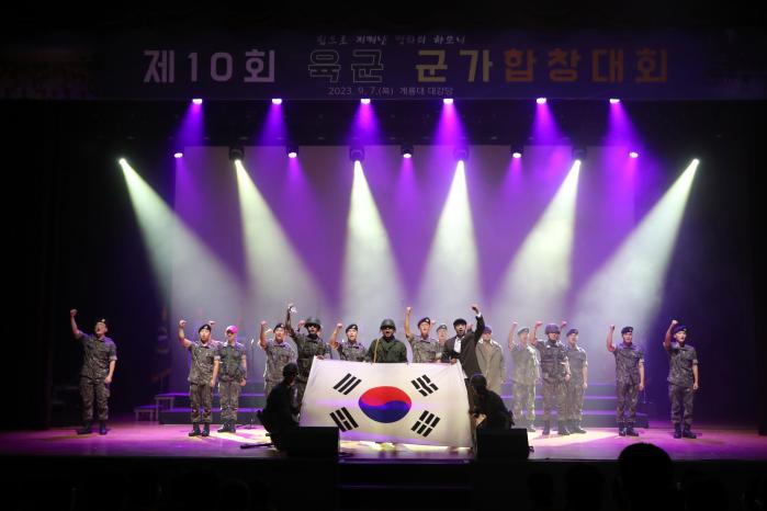 태극기를 펴 보이면서 합창하고 있는 1포병여단 칠봉부대 독수리대대 장병들.