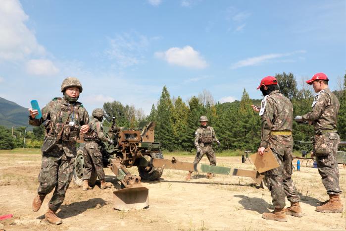 육군포병학교에서 열린 최정예 300 전투원 포술팀 선발대회 KH179 견인곡사포 직접사격 평가에서 한 장병이 평가관에게 받은 메시지 카드를 전파하기 위해 달려가고 있다. 부대 제공