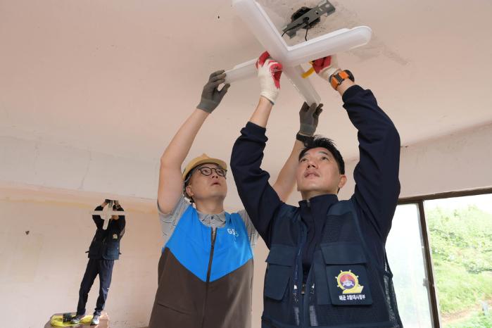 해군2함대 행복기동봉사단이 경기도 평택시 소사동 마을회관에서 낡은 전등을 교체하고 있다.